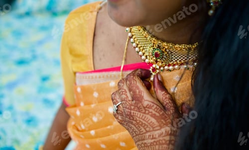 Preview: Close up of a women torching a necklace of a bride during traditional wedding ceremony in India
