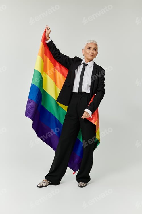 Preview: Stylish Mature Woman Celebrating Pride in Chic Attire With Rainbow Flag
