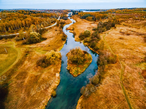 Preview: Aerial view of blue curve river and golden color fall autumn forest woods trees.