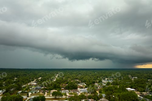 Preview: Dark stormy clouds forming on gloomy sky before heavy rainfall over suburban town area