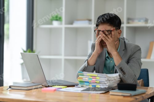 Preview: tired business man sleepy and bored from sitting at a desk for a long time and has office syndrome