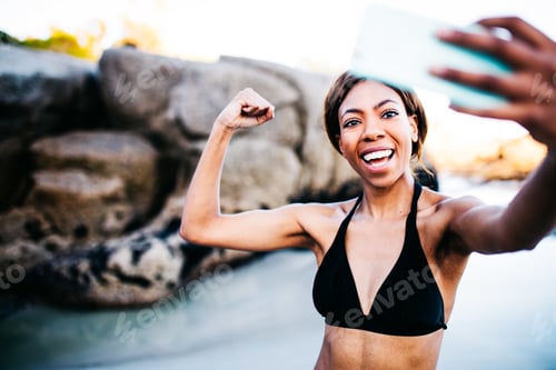 Preview: Fit Girl taking selfie with smartphone after workout at the beach