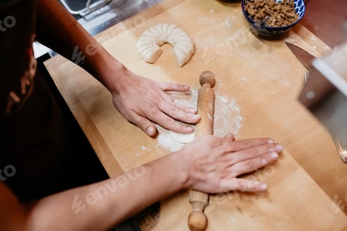 Preview: Hands rolling out dough on a kitchen counter with a rolling pin