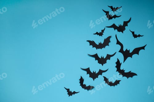 Preview: Flat lay composition with paper bats on light blue background, space for text. Halloween decor