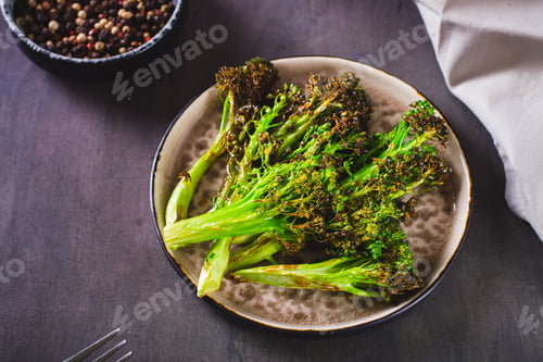 Preview: Roasted fresh broccoli sprouts in oil on a plate on the table