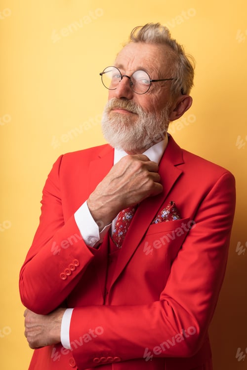 Preview: Old-aged dandy in red suit with necktie in floral print smiling at camera