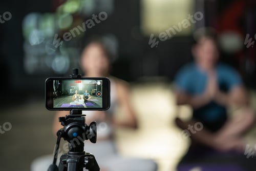 Preview: Asian yoga woman teacher teaching Caucasian man doing exercise and broadcast her class live online