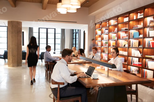 Preview: Colleagues working at desks in a busy open plan office area