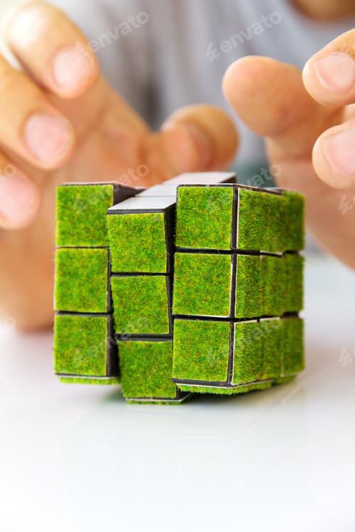 Preview: Hand holding green rubik's cube,green space concept