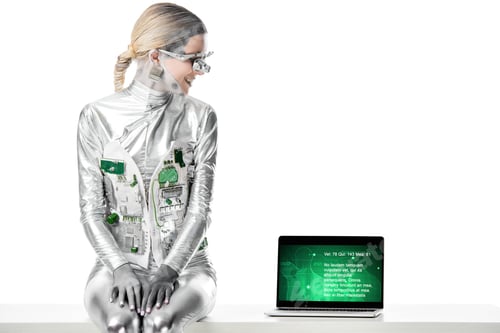 Preview: smiling silver robot sitting on table and looking at laptop with medical appliance isolated on