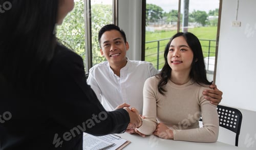 Preview: Happy Couple Signing Real Estate Sales Contract with Agent in Modern Office Setting