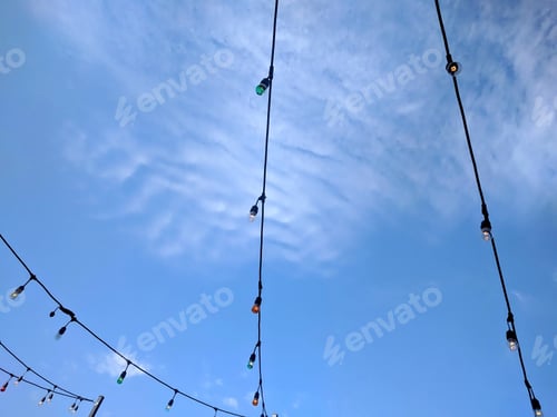 Preview: Strings Of Lights Against Blue Sky - Photograph Of Strings Of Multi Colored Lights Against A Blue