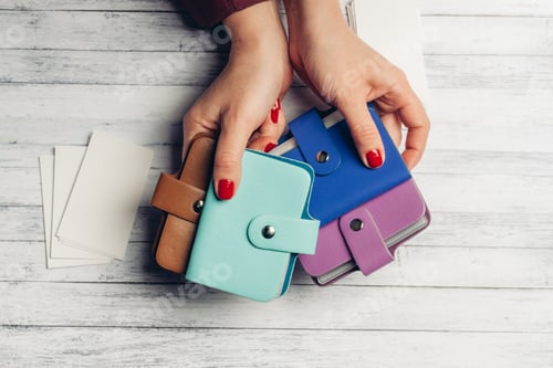 Preview: pack of white paper and multi-colored business card holders in female hands top view