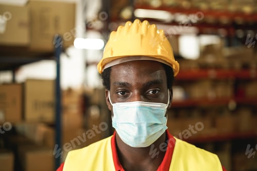 Preview: Portrait of happy african worker man inside warehouse while using face mask - Focus on face