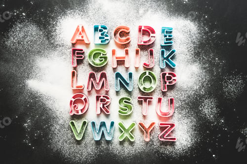 Preview: top view of baking forms for cookies in forms of letters with floor on tabletop, baking cookies