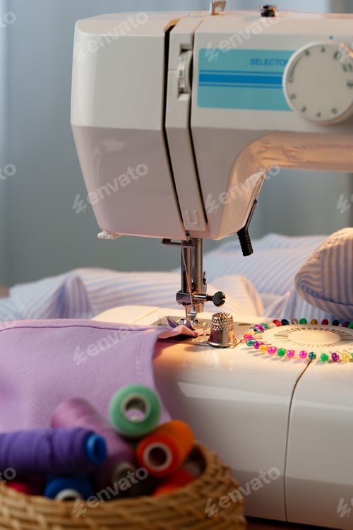Preview: Sewing machine in use on a wooden table, stitching a light fabric in a well-lit indoor workspace