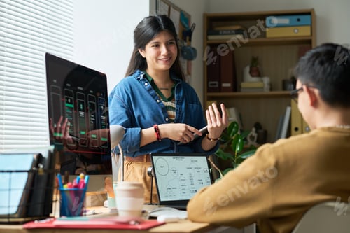 Preview: Hispanic Woman Explaining Project to Asian Man in Office