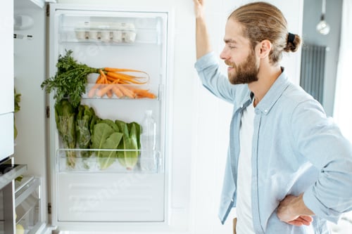 Preview: Man near the refrigerator full of healthy food at home