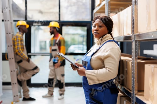 Preview: African american warehouse woman operator holding clipboard