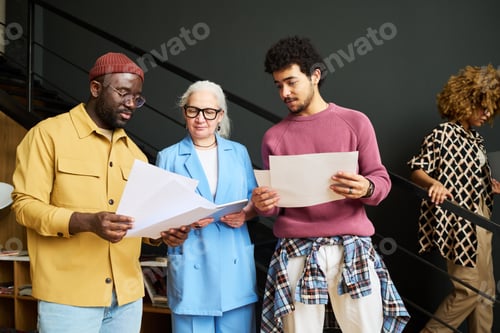 Preview: Group of intercultural economists discussing financial papers at meeting