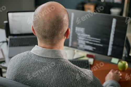 Preview: Middle Aged Caucasian Man Working on Computer Monitors in Office Setting
