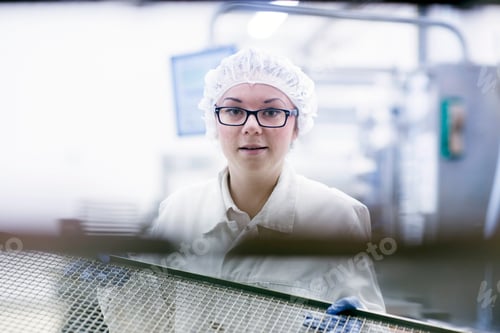 Preview: Factory worker wearing hair net looking at camera smiling