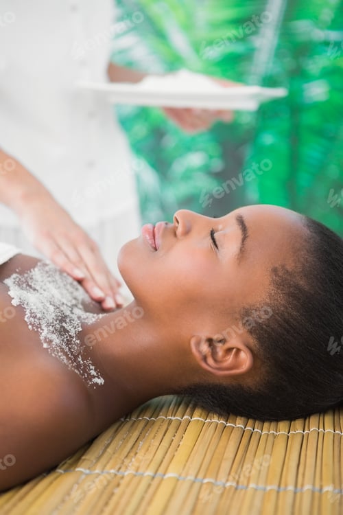 Preview: Side view of a pretty woman enjoying a salt scrub massage on the chest