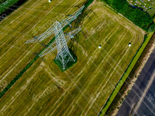 Preview: Aerial view of an electricity pylon amidst verdant fields