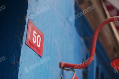 Preview: A Vibrantly Colored Blue Wall Featuring the Number 50 Accented with Red Detail and Artistry