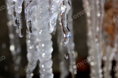 Preview: Icicles - Photograph Of Layers Of Icicles With Water Dripping Off Of Them And A Brown Background
