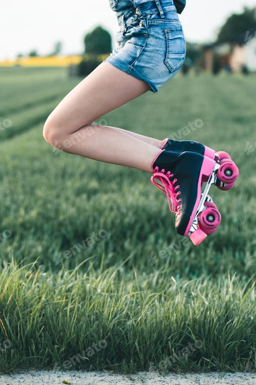 Preview: Teenage girl having fun rollerskating, jumping, spending time outdoors