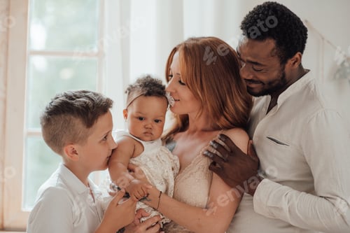 Visualização: Retrato de uma família inter-racial feliz e sincera com dois filhos passando um tempo juntos em casa
