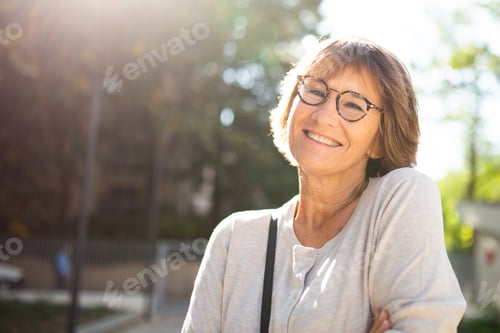 Preview: Close up older woman with eyeglasses smiling outside