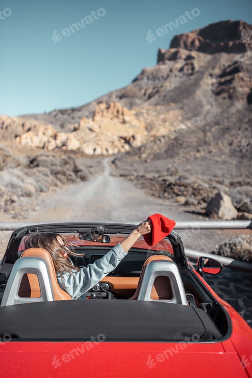 Preview: Woman traveling by cabriolet car on the desert road