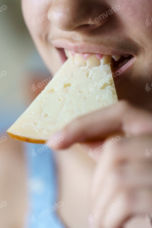 Preview: Happy anonymous girl biting fresh cheese slice