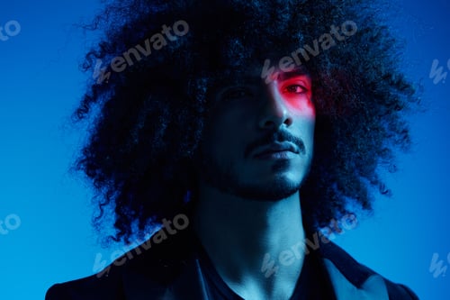 Preview: Fashion portrait of a man with curly hair on a blue background with a red stripe of light