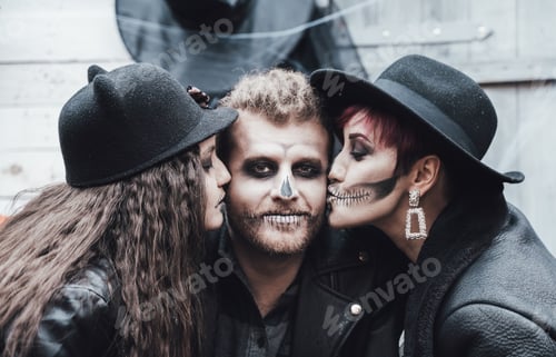 Preview: Scary family, mother, father, daughters celebrating halloween. Terrifying black skull half-face make