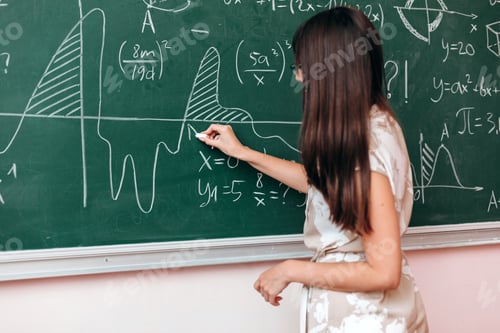 Preview: Teacher write an example on the blackboard and explain a lesson.- Image