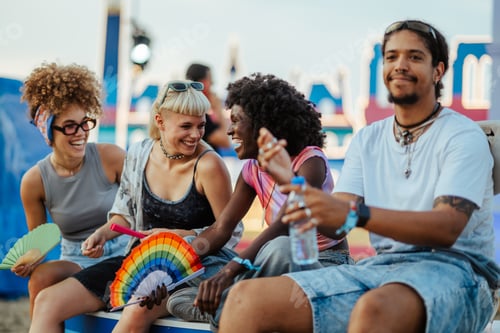 Preview: Young friends enjoying music festival, laughing and refreshing together