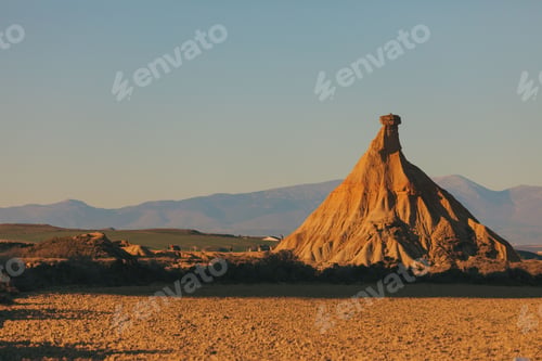 Preview: a rock formation in the desert with mountains in the background