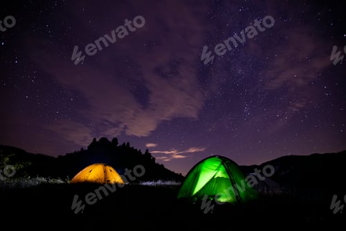 Preview: Starry night image with tents in the dark and the milky way. Wanderlust concept.