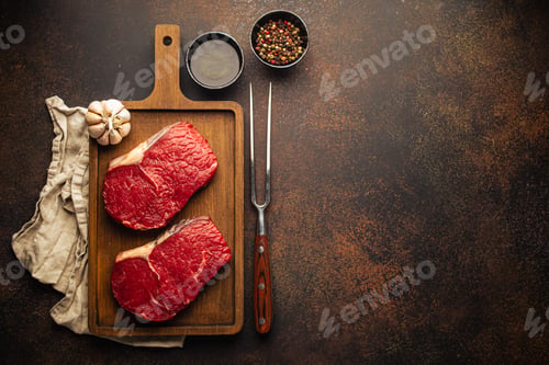 Preview: Two raw meat steaks on wooden board