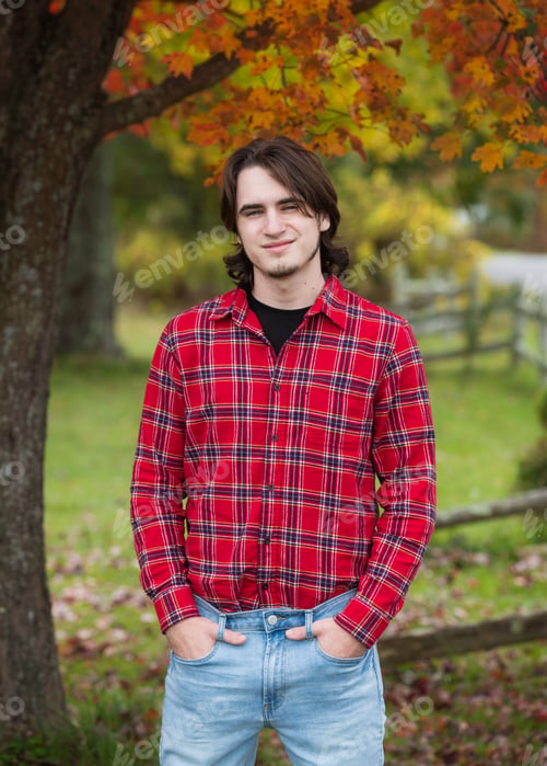Preview: Handsome young man standing outside in the fall