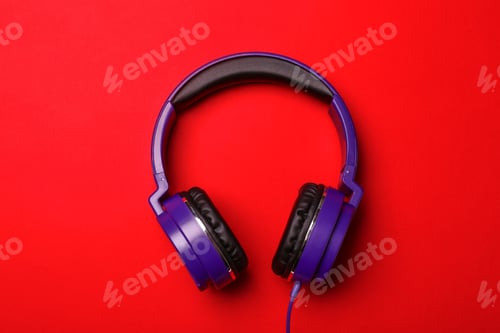 Preview: Stylish modern headphones on color background, top view