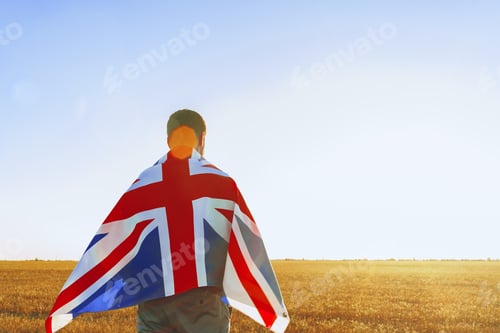Preview: Man with a flag of Great Britain standing in field