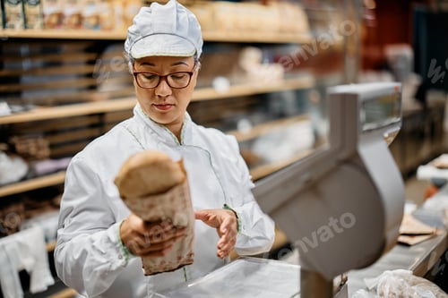 Preview: Mid adult woman working as supermarket baker.