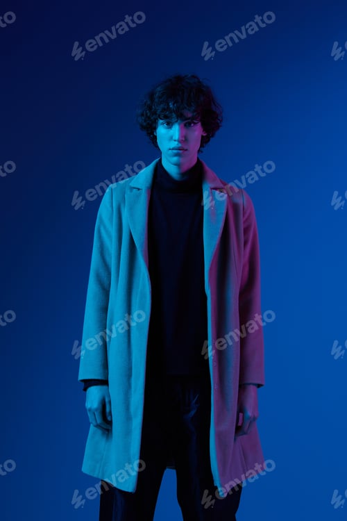 Preview: Man in hair dryer coat on dark blue background, neon light, style and trends