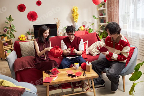 Preview: Young Asian Adults Preparing Tet Holiday Decorations in Living Room Together