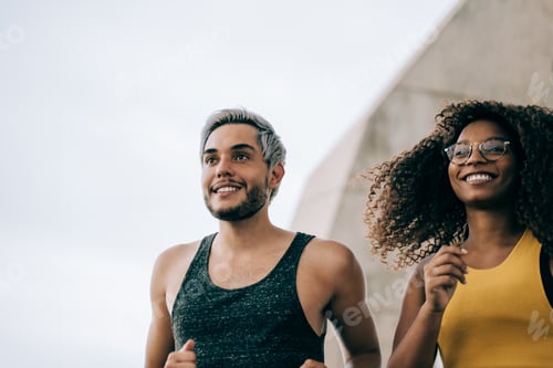 Preview: Young multiracial fit friends running outdoor in the city - Focus on african woman face