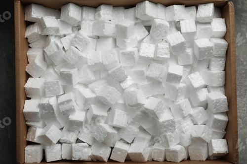 Preview: Cardboard box filled with polystyrene styrofoam pieces on grey background, top view